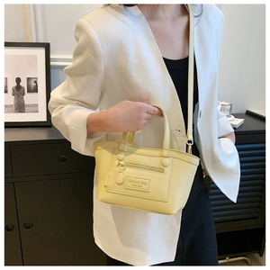 Gros plan sur le sac en cuir jaune clair avec fermetures éclair décoratives et poignée haute