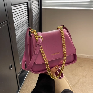 Purple textured leather crossbody bag with chunky gold chain strap and brand logo