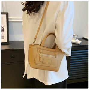 Détail d'un sac à bandoulière en cuir PU kaki avec fermetures éclair et boucles métalliques
