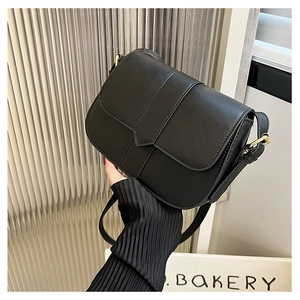 Detail der minimalistischen schwarzen Satteltasche mit mattem Leder und Goldschließe