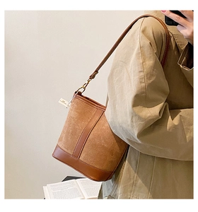 Close-up of retro brown frosted leather bucket bag with vertical stitching and smooth base