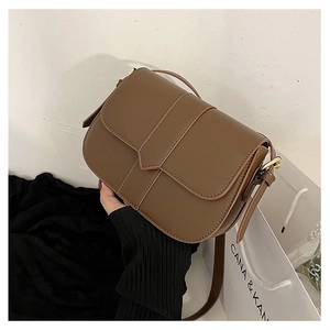 Detailaufnahme der karamellbraunen Satteltasche aus Leder mit goldener Hardware und Riemen