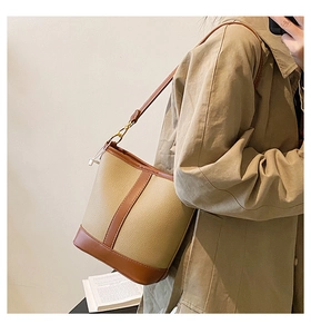 Detail of vintage patchwork bucket bag featuring pebble grain texture and gold buckles