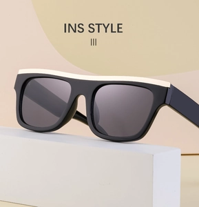 Modern black cat-eye sunglasses with cream top accent on geometric background