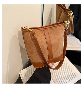 Detail view of brown vintage bucket bag featuring suede and leather texture stitching
