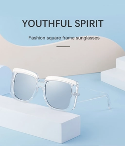 Détail de lunettes de soleil carrées transparentes avec verres argentés et bord blanc