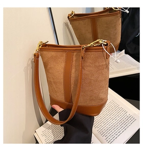 Detail view of brown bucket bag showing contrast stitching and premium leather textures