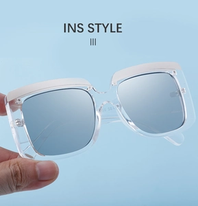 Détail de lunettes de soleil carrées bleu clair avec insert métallique et monture translucide