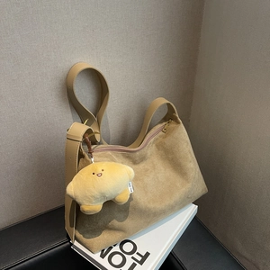 Matte brown faux suede tote bag with stylish croissant plush charm and adjustable strap