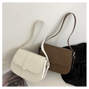 Detail minimalistischer Satteltaschen in Creme und Braun mit matter Lederklappe