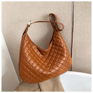 Detail of caramel brown quilted hobo bag with adjustable strap and vintage texture