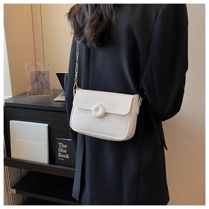 Lifestyle view of cream white flap crossbody bag with gold chain strap on shoulder