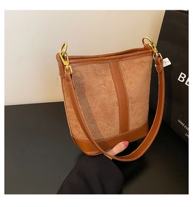 Detailed view of the mixed-texture brown bucket bag with gold hardware and suede panels