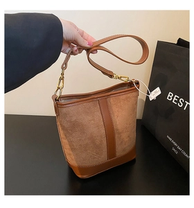 Detail of vintage patchwork bucket bag with contrast stitching and golden hardware