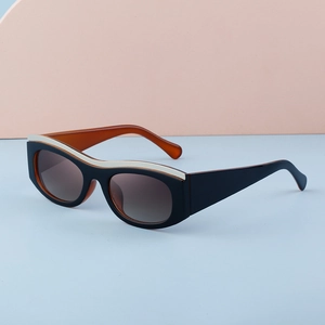 Detail of cat eye sunglasses with amber temples and gold trim on black frame