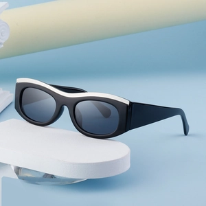 Chic cat eye sunglasses with thick black frames and white streamline accents on geometric stand