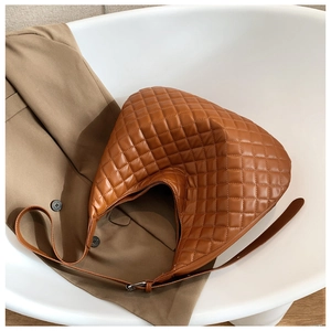 Detail shot of brown quilted hobo bag with adjustable strap in a lifestyle setting