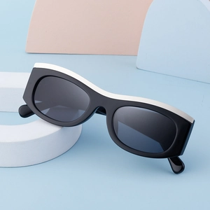 Detail of retro cat eye sunglasses with thick black frame and white contrast trim on top