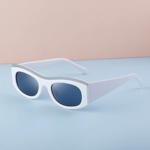 Close-up of white cat-eye sunglasses with silver metal brow trim and gray lenses