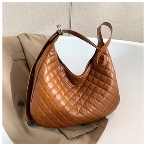 Detail of brown quilted hobo shoulder bag featuring large capacity and wide adjustable strap