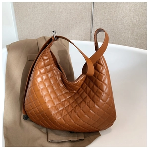 Detail of brown quilted hobo bag with padded diamond stitching and wide shoulder strap