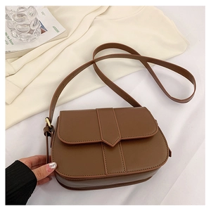 Detail der dunkelbraunen Vintage-Satteltasche mit spitzem Lederband und rundem Boden