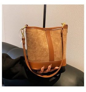 Detail of vintage brown bucket bag showing suede and smooth leather stitching texture