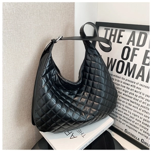 Detailed view of black quilted faux leather hobo bag with adjustable strap and silver hardware