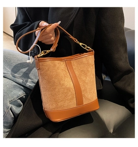 Close-up of caramel bucket bag showing suede and smooth leather texture with gold hardware
