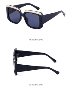 Détail de lunettes de soleil carrées avec monture noire et accents en métal doré sur le côté