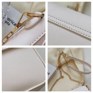 Detailed macro view of light gold hardware and neat stitching on cream square bag