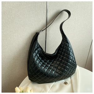 Detail of black quilted hobo bag featuring diamond stitching and adjustable strap