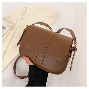 Nahaufnahme einer braunen Satteltasche im Vintage-Stil mit Riemen und goldenen Beschlägen