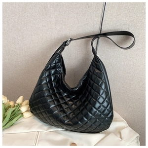 Detail of black quilted Hobo bag featuring adjustable silver metal buckle and PU texture