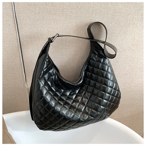 Detailed close-up of a black quilted hobo bag featuring a wide adjustable shoulder strap