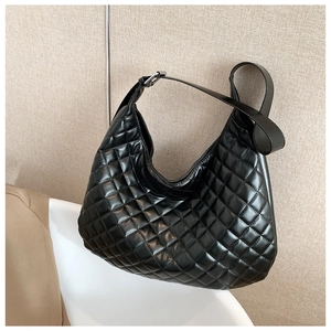 Macro shot of black quilted large crescent bag with silver buckles and leather texture