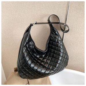 Detail of the black quilted rhombic stitching on a stylish crescent shoulder bag