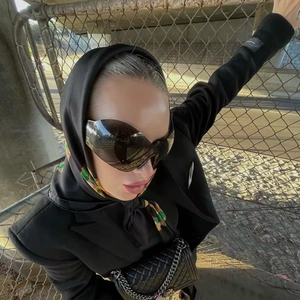 Y2K wraparound sunglasses paired with a quilted chain handbag in an urban setting