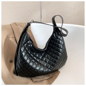 Detail of black quilted leather hobo bag with silver buckle and adjustable strap