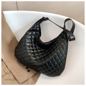 Detailed close-up of black quilted hobo bag featuring premium stitching on white pedestal