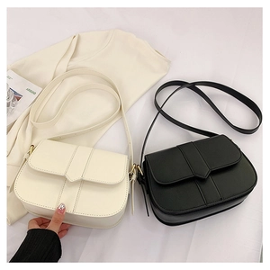 Detailansicht eleganter Satteltaschen aus Leder in Beige und Schwarz mit Klappverschluss