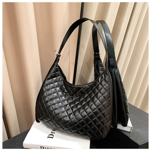 Close-up of quilted black PU leather hobo bag with adjustable wide strap and silver buckle