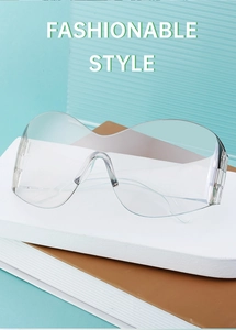 Close-up of transparent Y2K oversized rimless sunglasses on book props with blue background