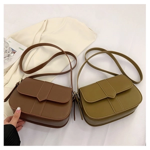 Flache Ansicht von braunen und olivgrünen matten Leder-Satteltaschen mit Klappendetail