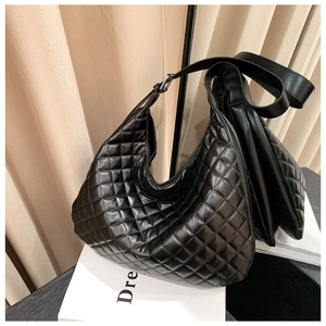 Detail of black quilted leather hobo bag with adjustable silver buckle and glossy texture