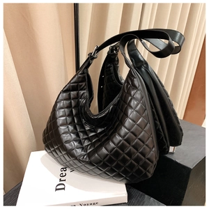 Close-up of black quilted shoulder bag with wide adjustable strap and large capacity