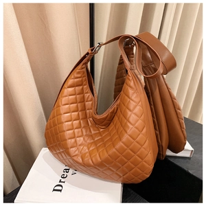 Close-up of quilted caramel leather texture and silver buckle on the shoulder bag