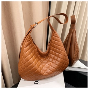 Close-up of caramel quilted leather hobo bag with adjustable strap and silver buckle