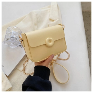Minimalist light yellow crossbody bag with chain strap and round donut buckle detail
