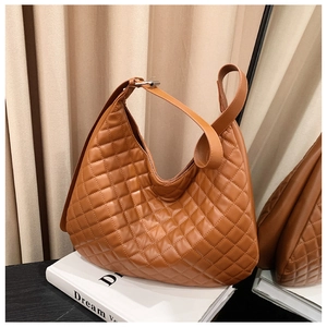 Detailed view of brown quilted hobo bag with adjustable strap and silver metal buckle